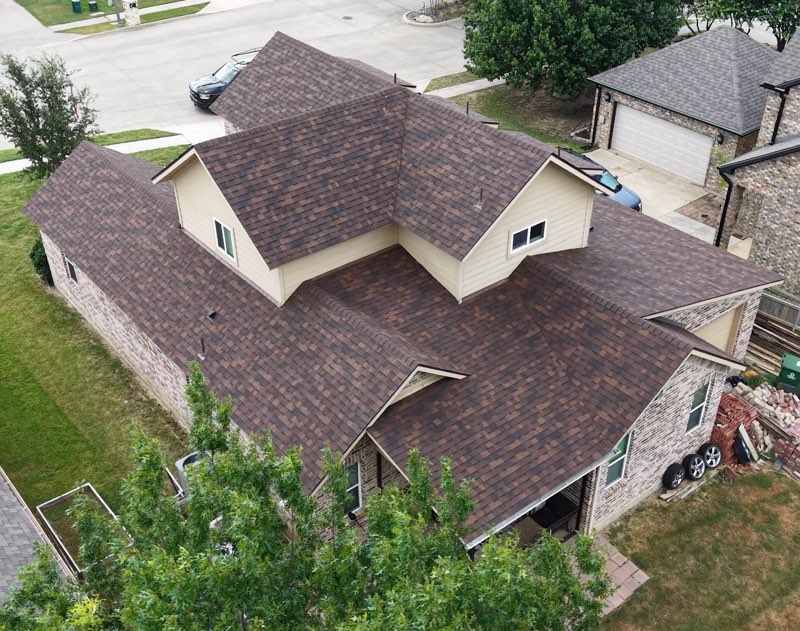 Drone view of a finished brown shingle roof with clean valleys and dormers